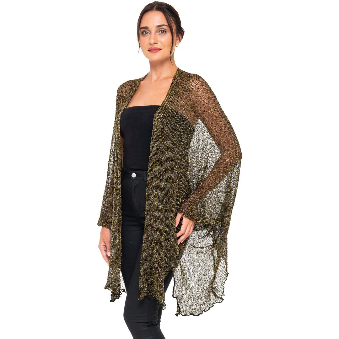 SHU-SHI black and gold metallic cardigan with sheer, sparkly fabric worn open over a black strapless top and black pants against a white studio background.