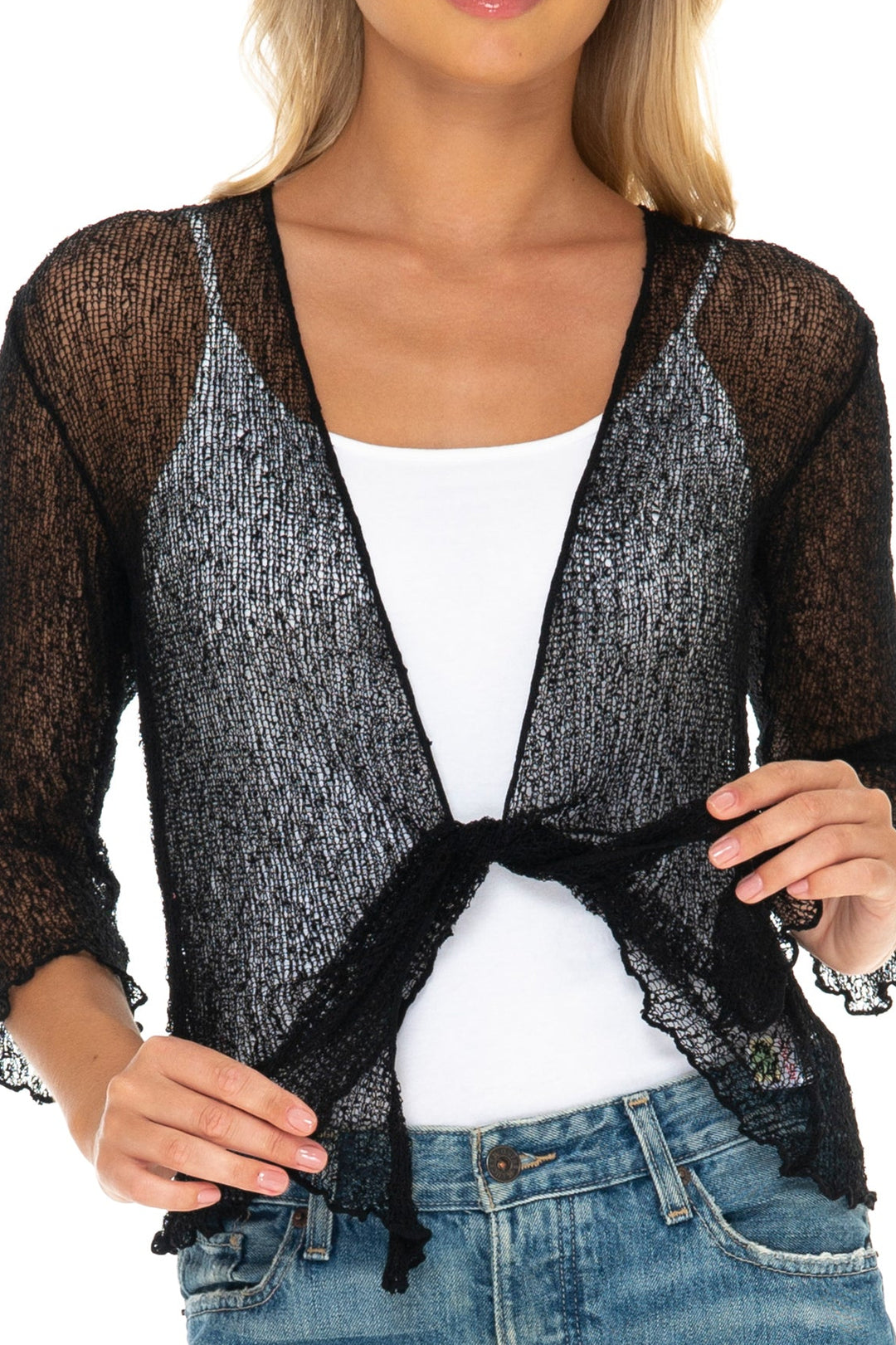A woman wearing a SHU-SHI black sheer open-front cardigan overt white tank top and blue jeans, close up of the fabric to show texture. 