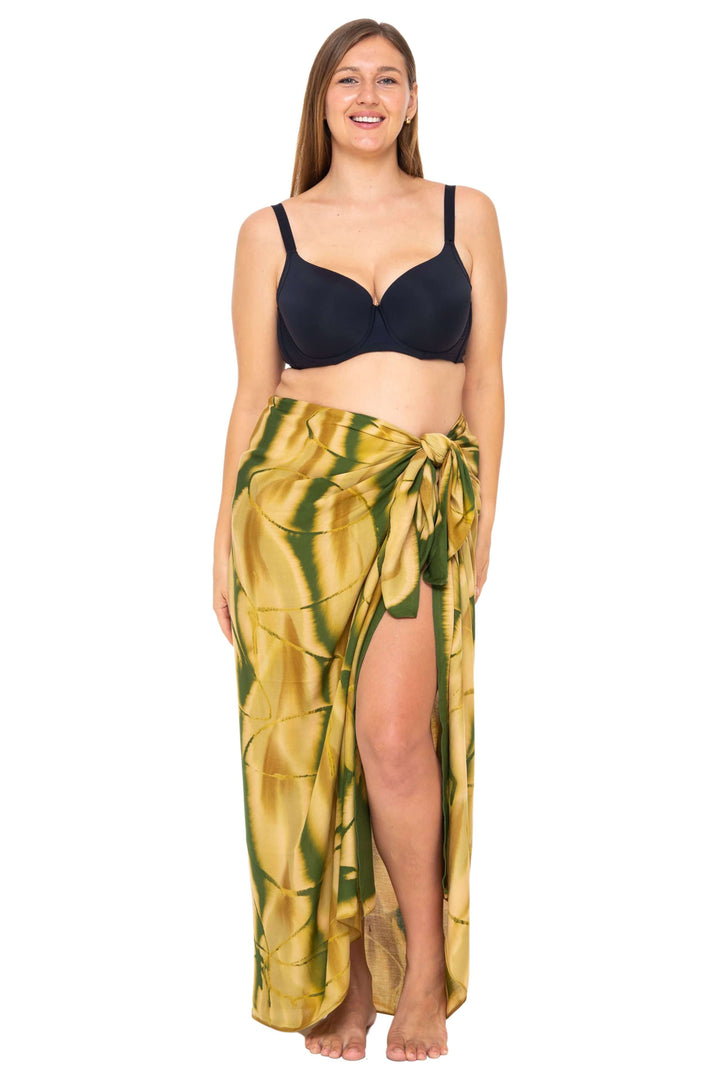 Woman wearing a black bikini and a Olive  Tie-Dye Sarong Wrap Cover-Up for Women by SHU-SHI, styled as a long wrap skirt. Lightweight rayon beach cover-up, perfect for vacations, poolside lounging, tropical beach getaways, cruises, and resort wear.